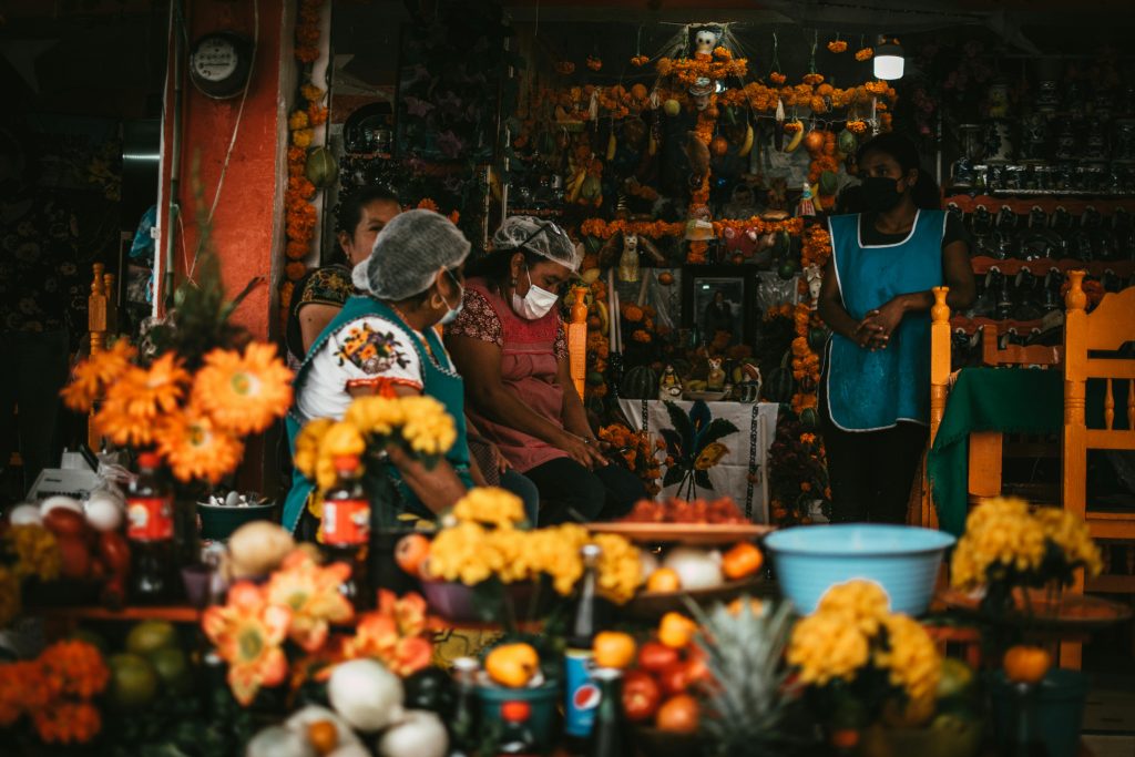 A vibrant Day of the Dead display with people preparing offerings in Janitzio, Michoacán, México.