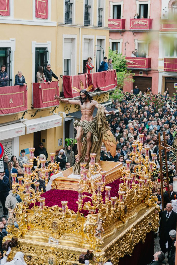 Vibrant Holy Week procession with a religious float in the streets of Seville.